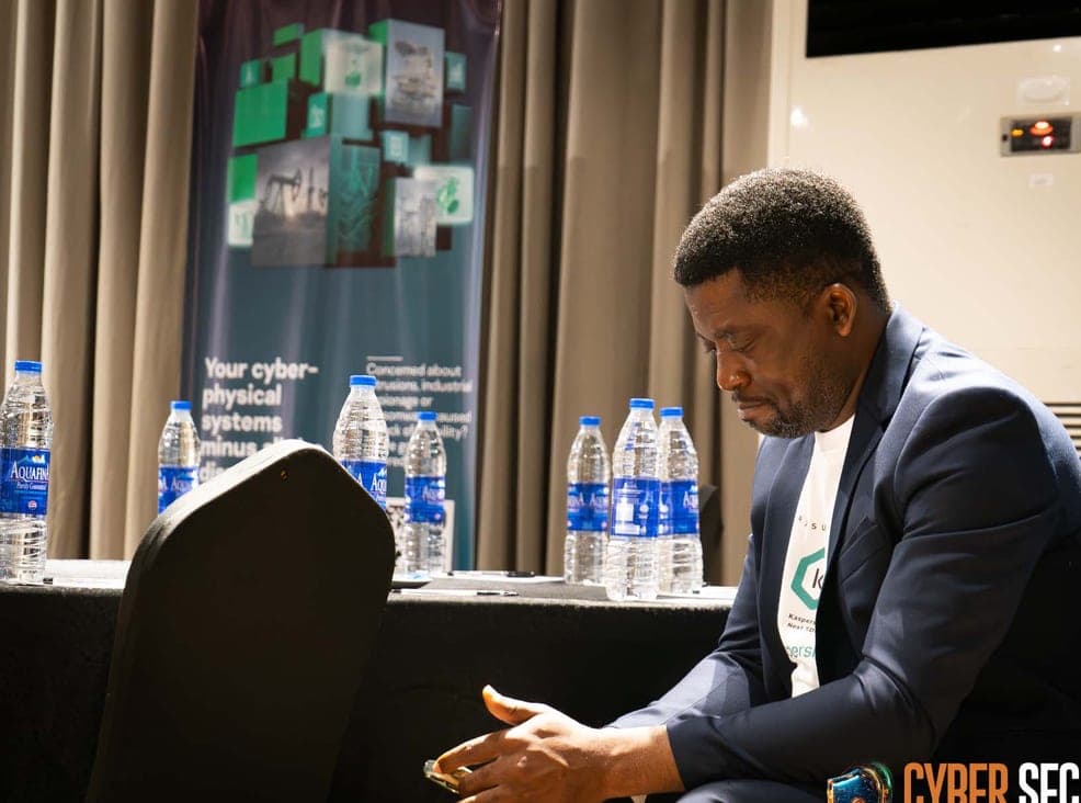 Segun Akande preparing notes at a speaker's table
